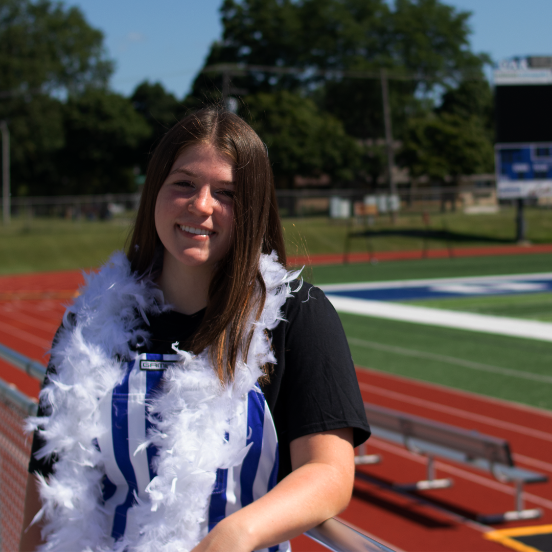 A person wearing gameday apparel near the Oak Creek Football Field.