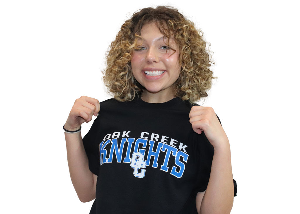 Black t shirt with writing across the upper chest saying Oak Creek Knights with and OC logo.