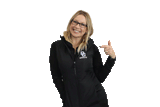 Blonde woman wearing a black OC Knights embordered vest and pointing to it.