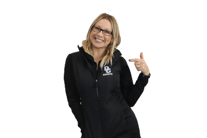 Blonde woman wearing a black OC Knights embordered vest and pointing to it.