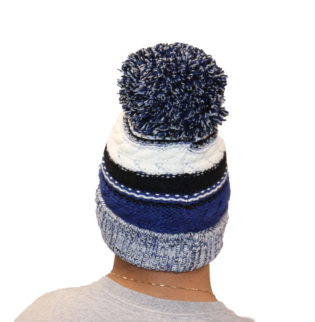 Blue, black, and white hat with puff ball at the top. OC logo on fold over